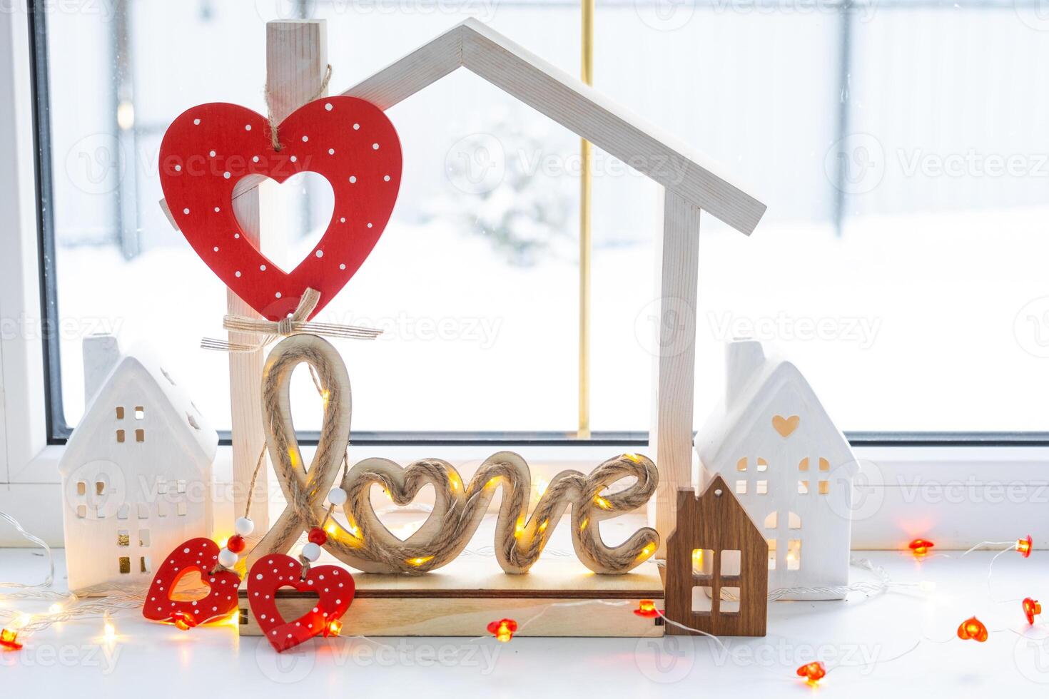 Key to tiny house of cozy home with Valentine decor on the windowsill. Gift for valentines day, family love nest. design, project, moving to new house, mortgage, rent and purchase real estate photo