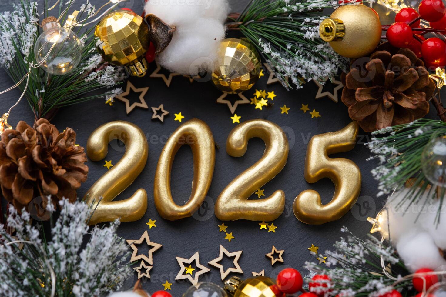 The golden figures 2025 made of candles on a black stone slate background are decorated with a festive decor of stars, sequins, fir branches, balls and garlands. Greeting card, happy New Year. photo