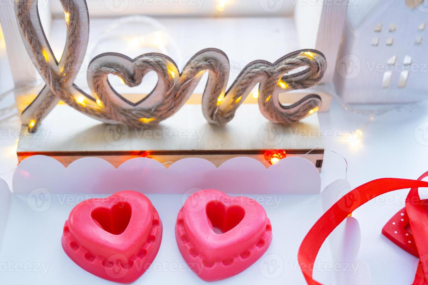 Handmade homemade soap in the shape of hearts for a Valentine's Day gift to your beloved. Perfumes and dyes, soap base on the table photo