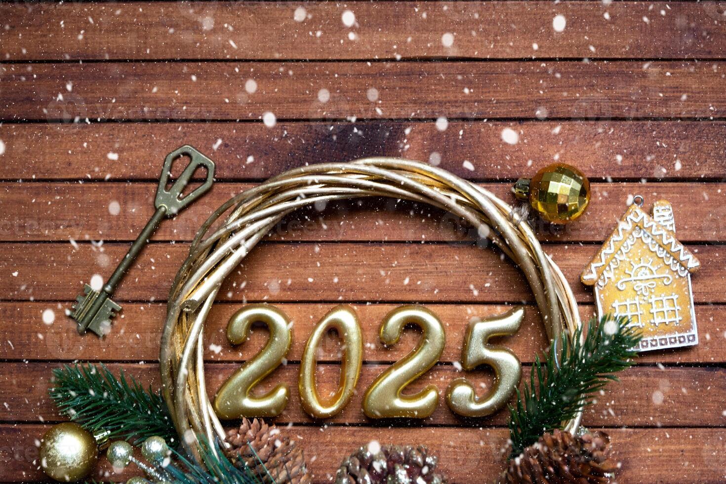 New Year House key with keychain cottage on festive brown wooden background with number 2025 in wreath, lights of garlands. Purchase, construction, relocation, mortgage, insurance photo