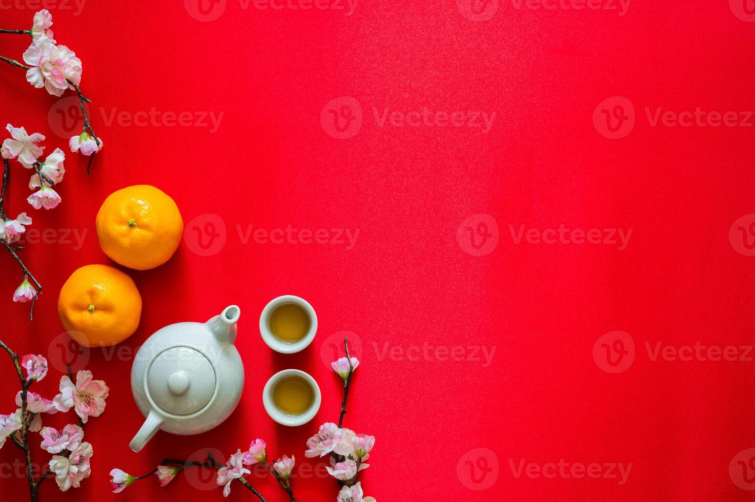 Tea set with oranges and peach blossom on red cloth background for Chinese new year concept. photo