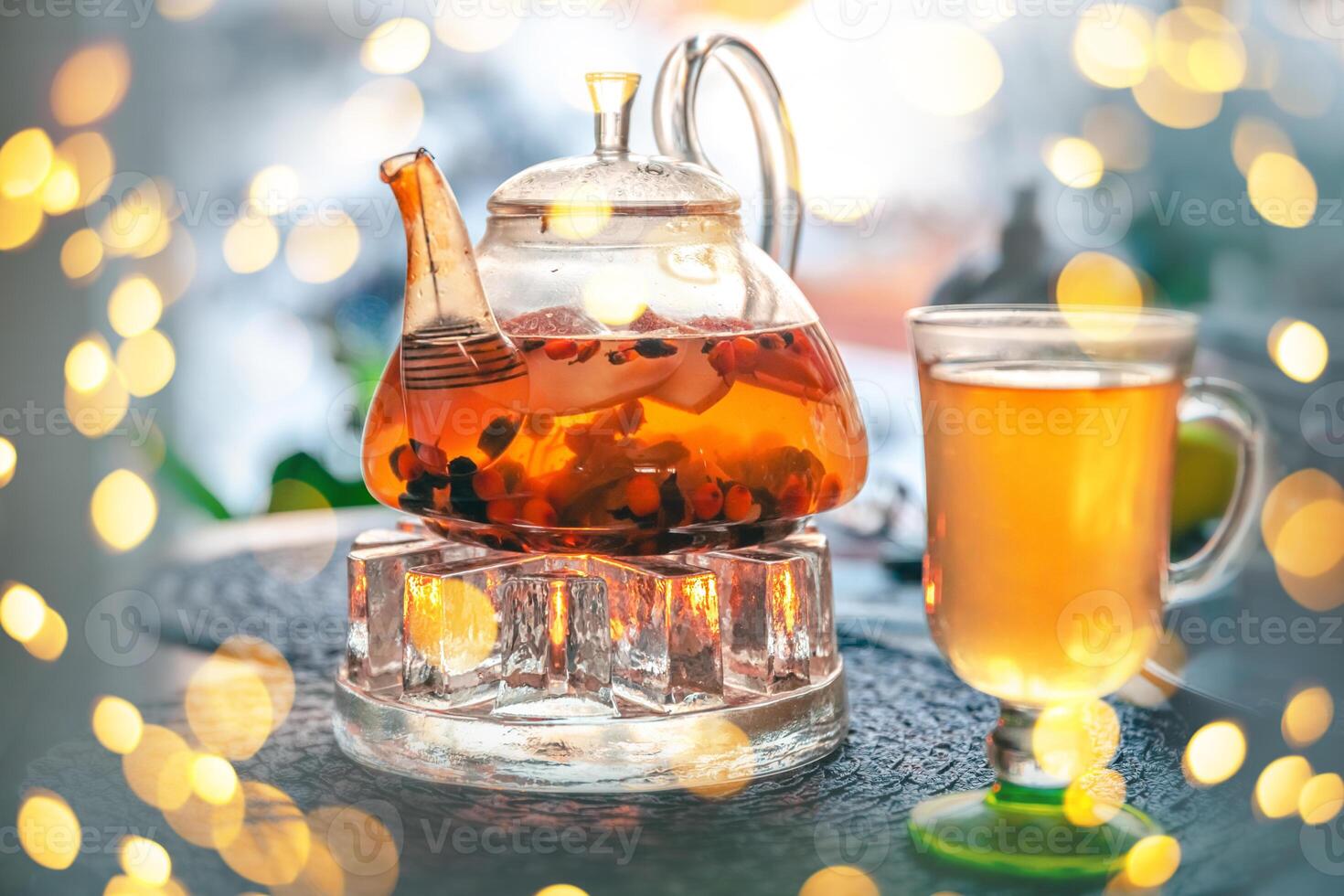Tea in a glass teapot on a background of bokeh photo