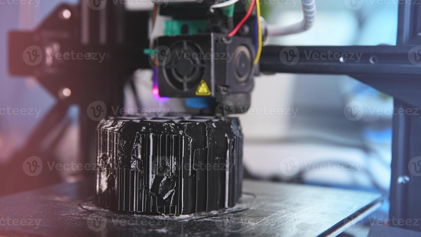 A 3D printer prints a black model. Technology at home photo