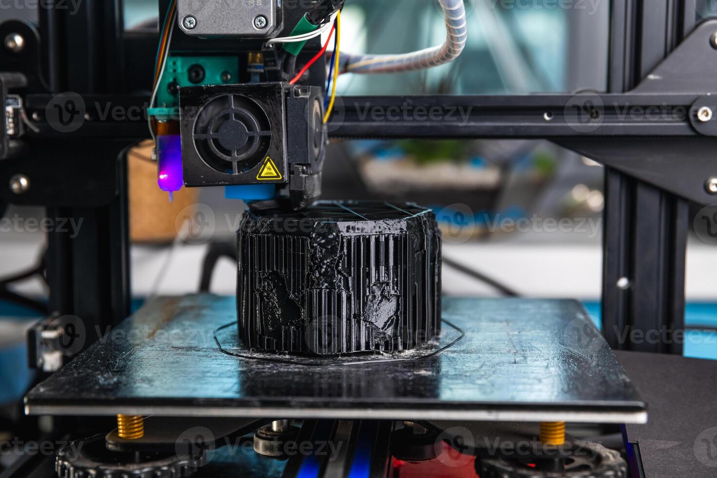 A 3D printer prints a black model. Technology at home photo