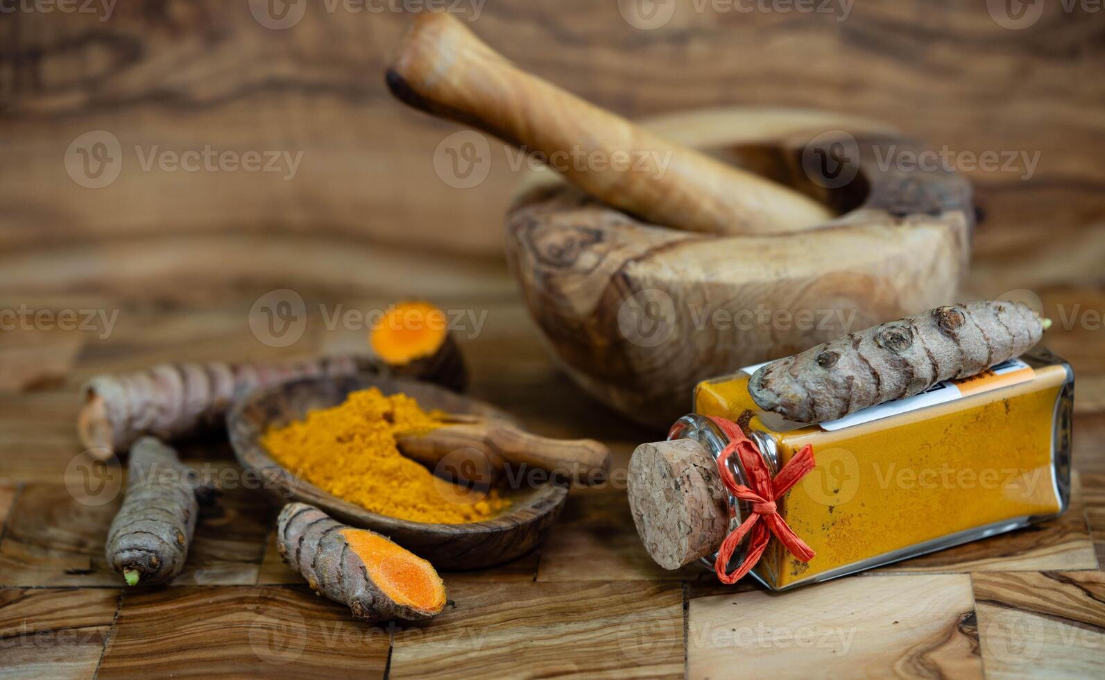 Turmeric Curcuma longa the yellow spice on olive wood photo