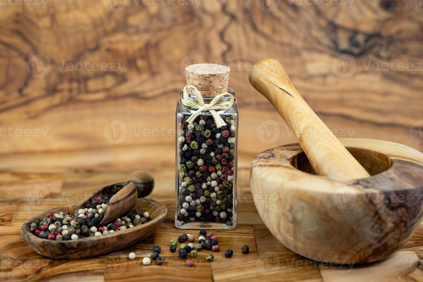 a stack of peppercorns on olive wood photo