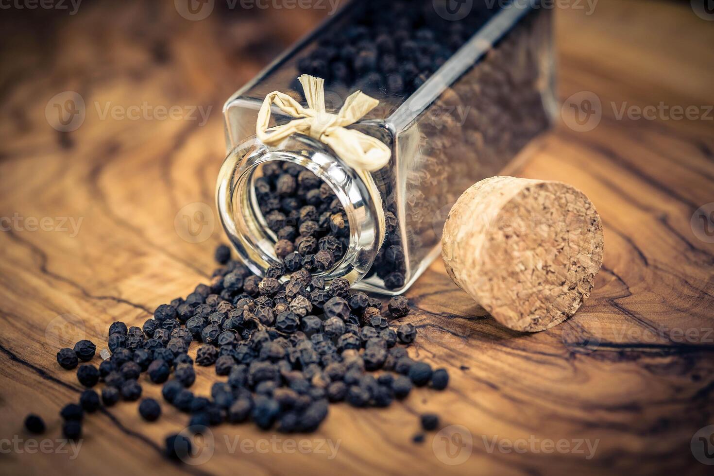 a stack of peppercorns on olive wood photo