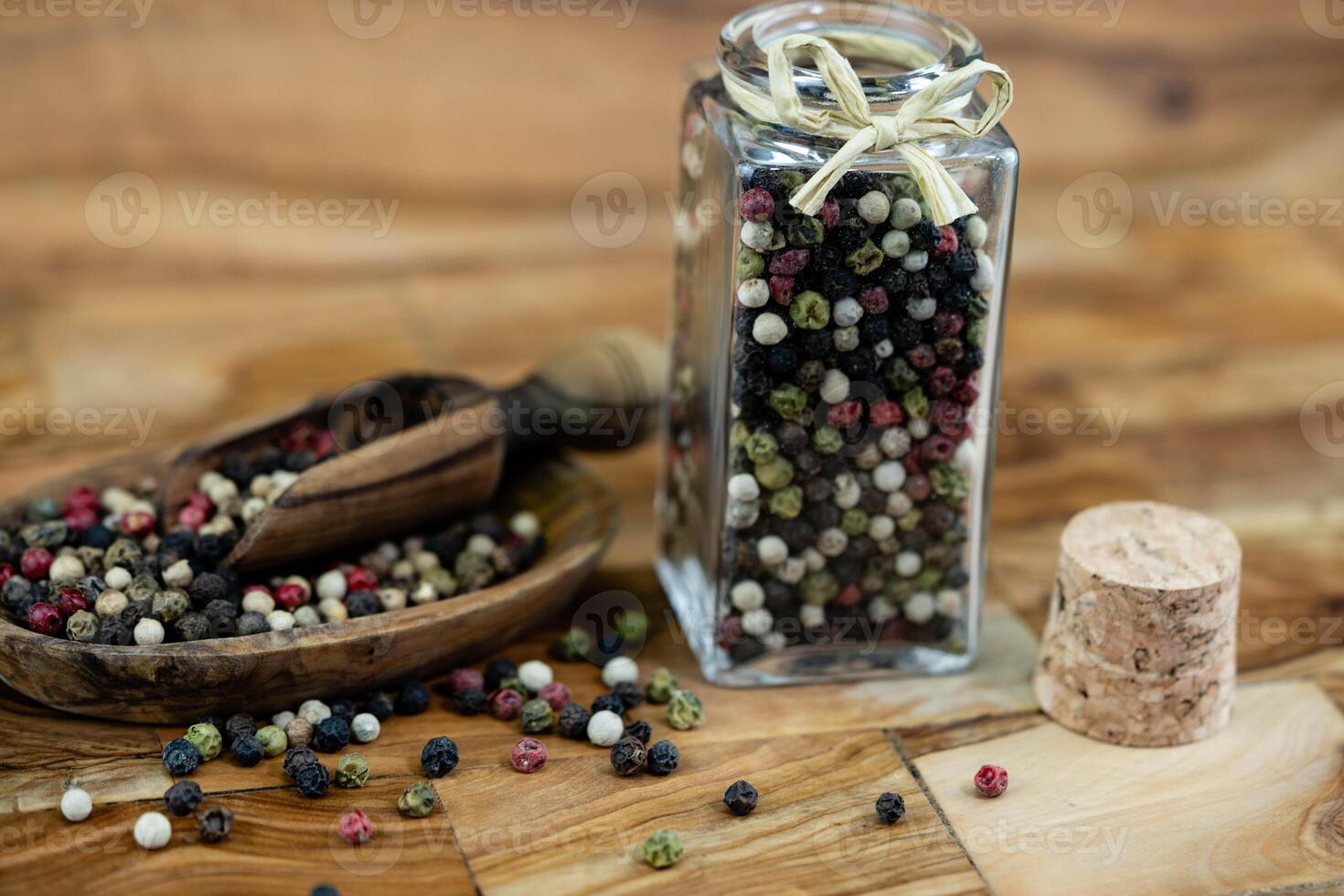 a stack of peppercorns on olive wood photo