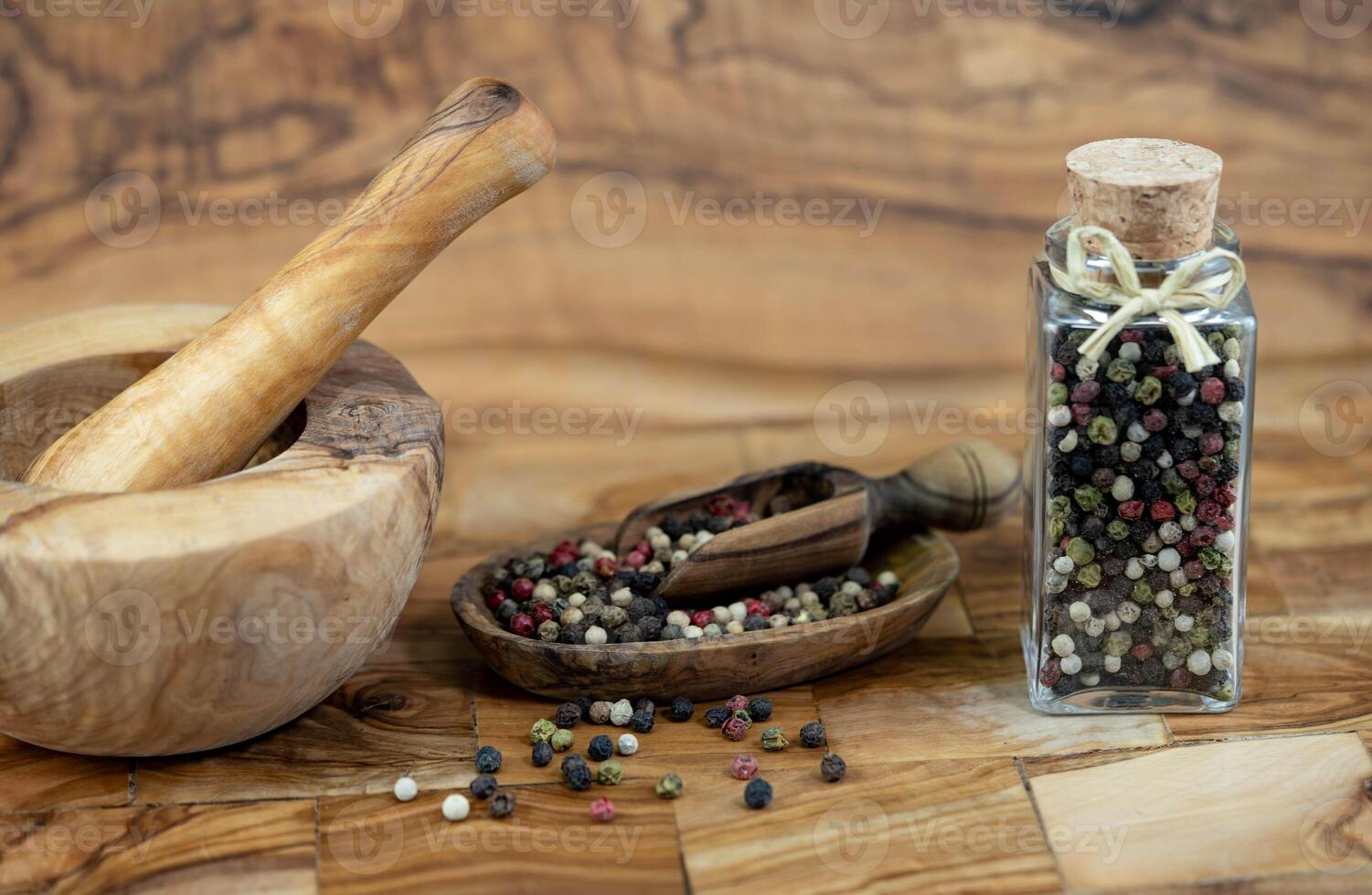 a stack of peppercorns on olive wood photo