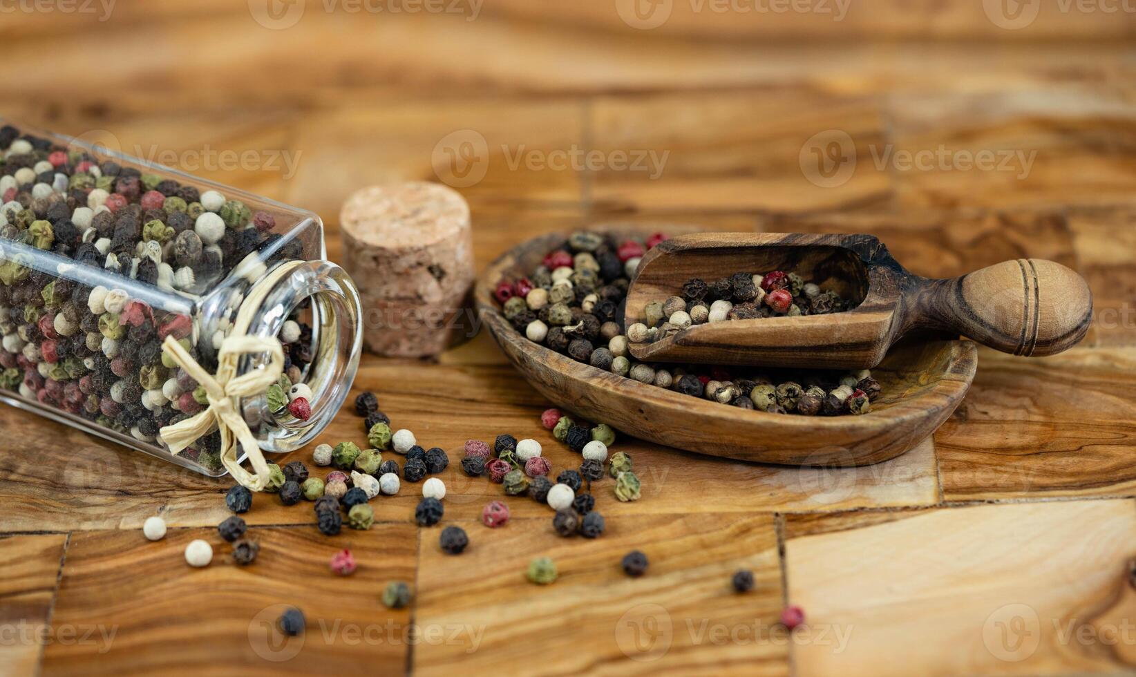 a stack of peppercorns on olive wood photo