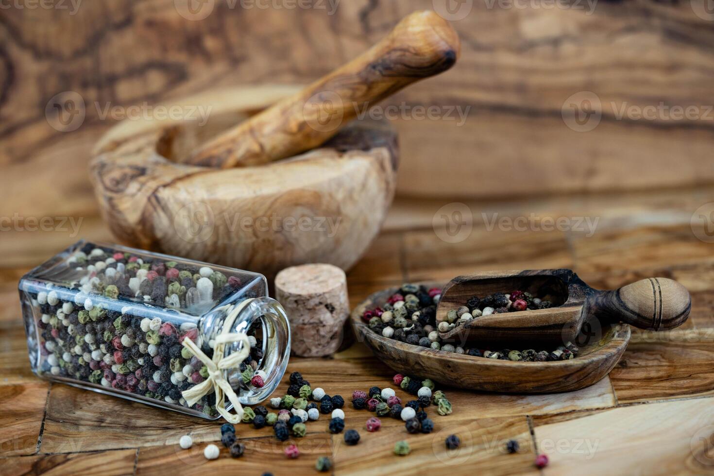 a stack of peppercorns on olive wood photo