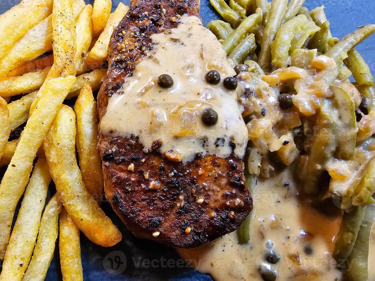 french Peppersteak with green Pepper  green beans and pommes frites photo