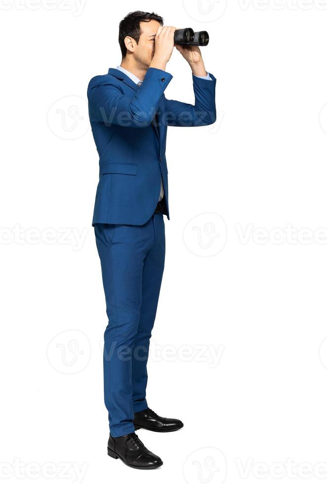 Businessman looking through binoculars isolated on white photo