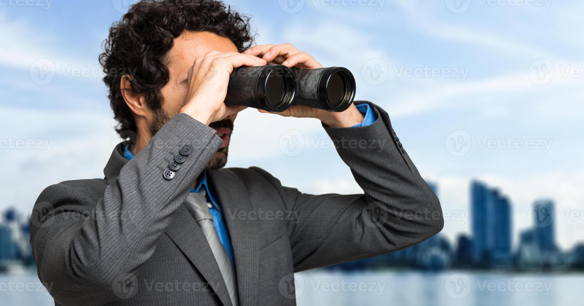 Businessman looking through binoculars photo