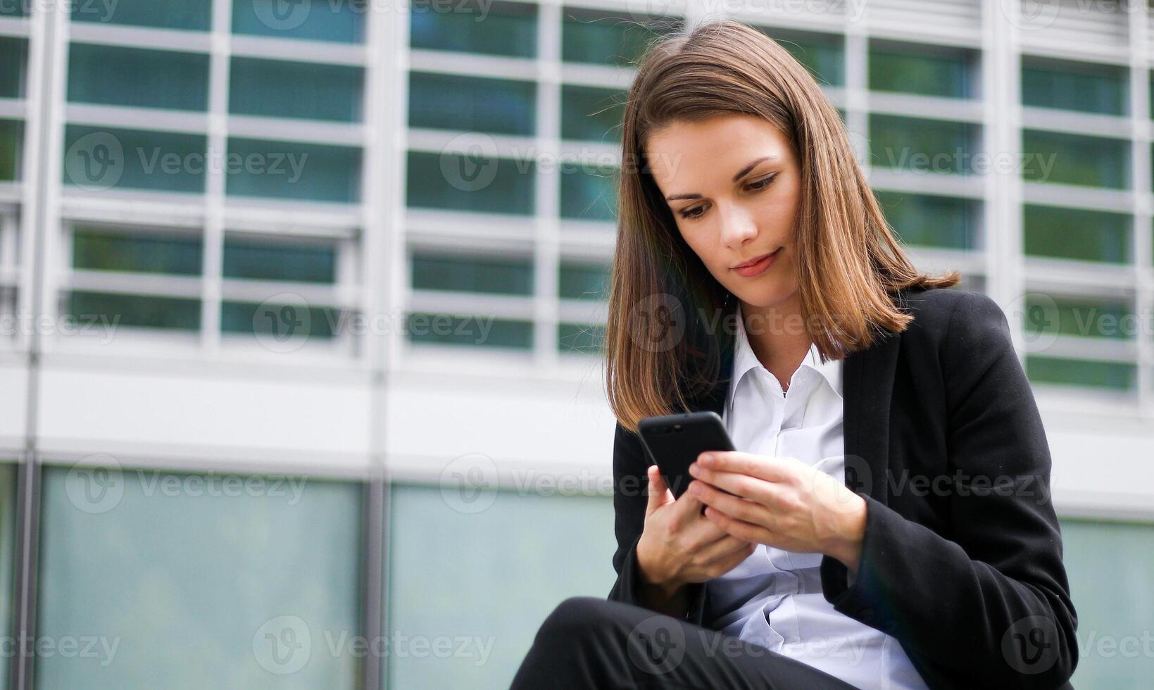 Portrait of a young woman talking on the phone sitting on a bench outdoor photo