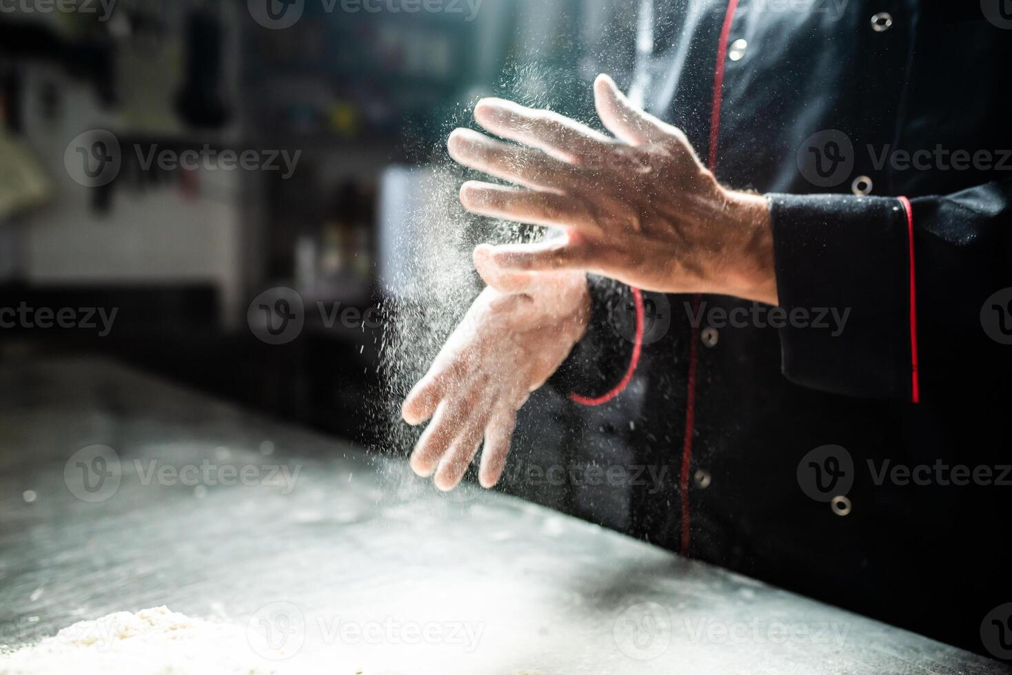 Closeup of chef's hands sprinkling flour photo
