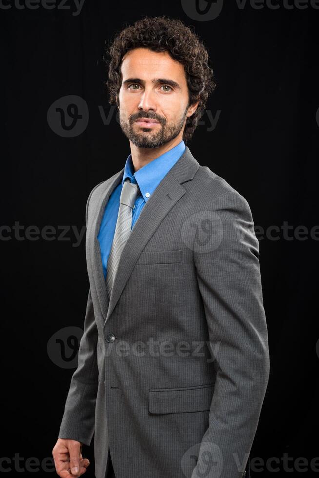 Portrait of a handsome businessman isolated on black photo