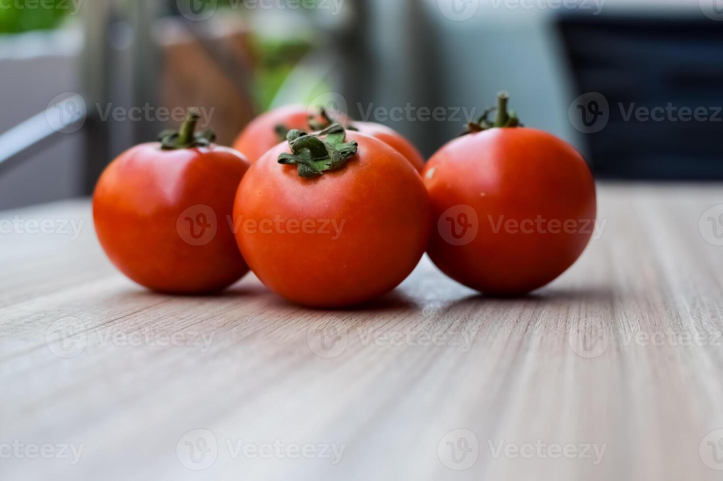 Red tomato on plain wooden table, essential vegetables for all essential foods, view of unpeeled vegetables with plain background photo