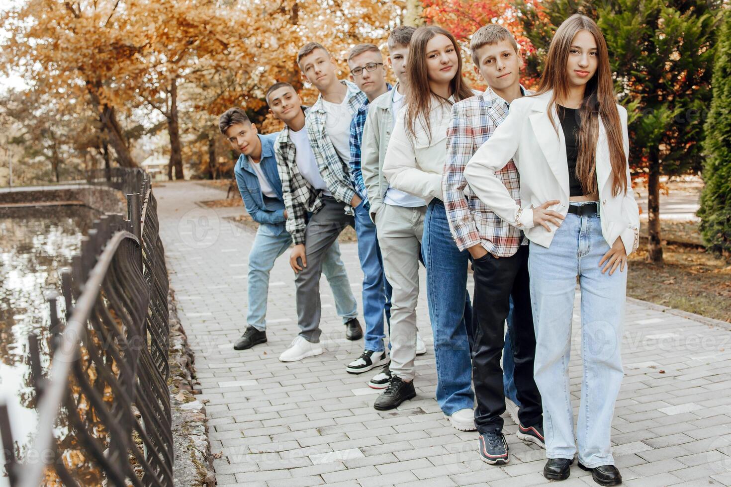 friendship, movement, action, freedom and people concept - group of happy teenagers or school friends posing and having fun outdoors against nature or forest background. photo