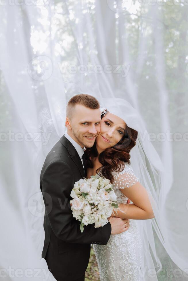 boda. amor y Pareja en jardín para boda. celebracion de ceremonia y compromiso. salvar el fecha. confianza. el novia y novio abarcar. el novio abraza el novia debajo el velo. foto