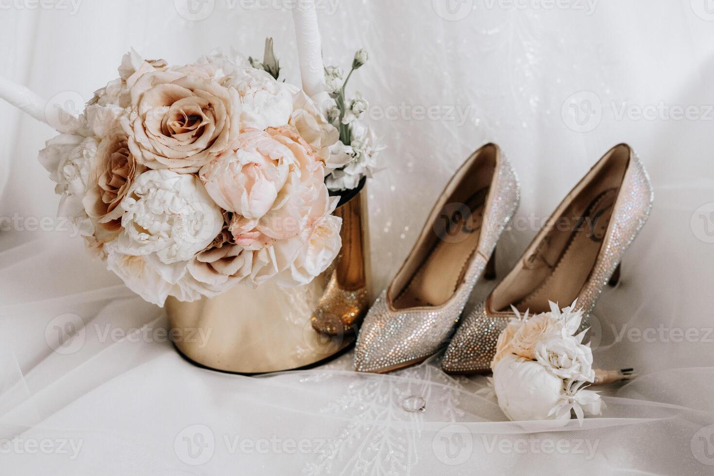 The bride's engagement ring, fashionable stilettos, fresh rose flowers. Wedding details in golden style. photo