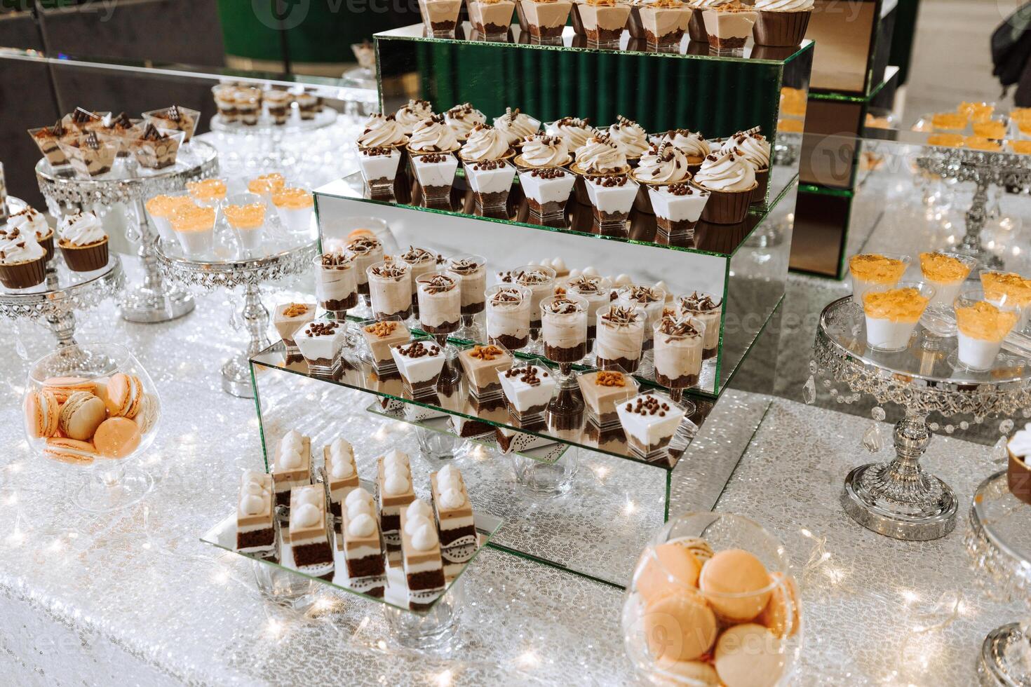 Candy bar for a wedding. Candy bar standing festive table with desserts, cupcakes and macarons. Beautiful and tasty. photo