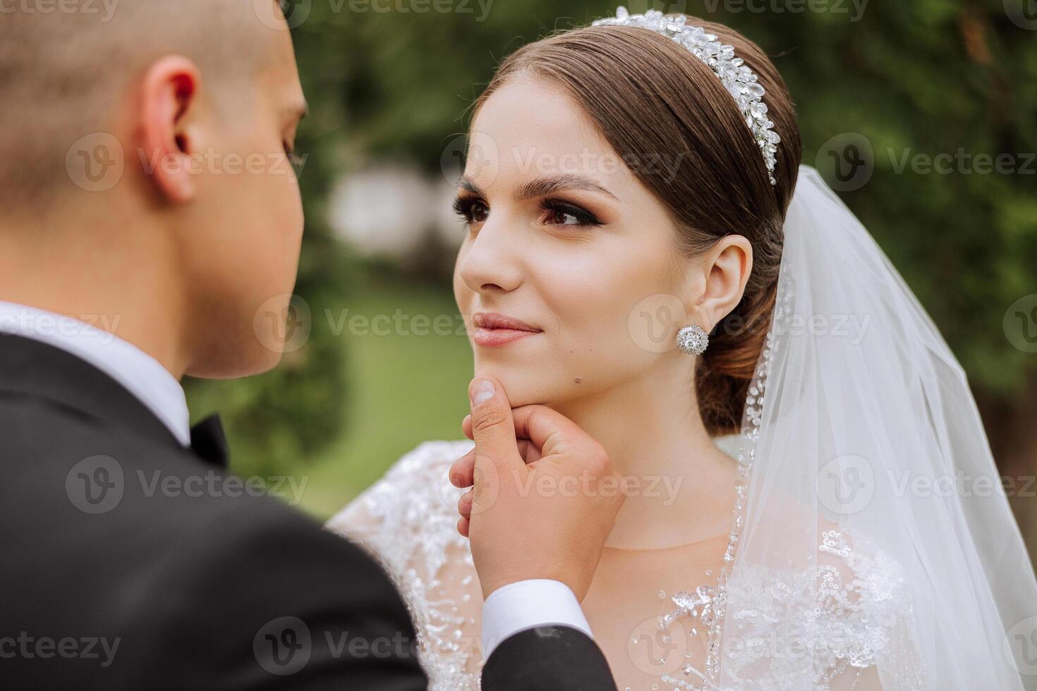 Wedding. Love and couple in garden for wedding. Celebrating the ceremony and commitment. Save the date. Trust. The groom gently touches the face of the bride. Couple in love. Wedding portrait photo