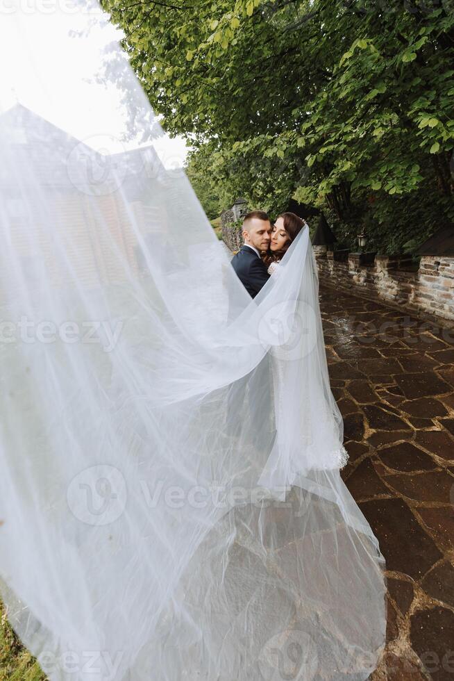 Couple, love, wedding dress and long veil, after marriage event, ceremony or union in nature. Smiling, happy or trusting man or woman or bride and groom getting closer after a romantic celebration. photo