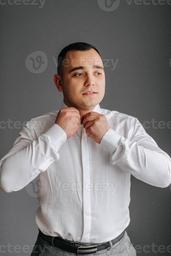 el novio botones su camisa en su habitación. Boda detalles. de los hombres estilo. retrato de el novio foto