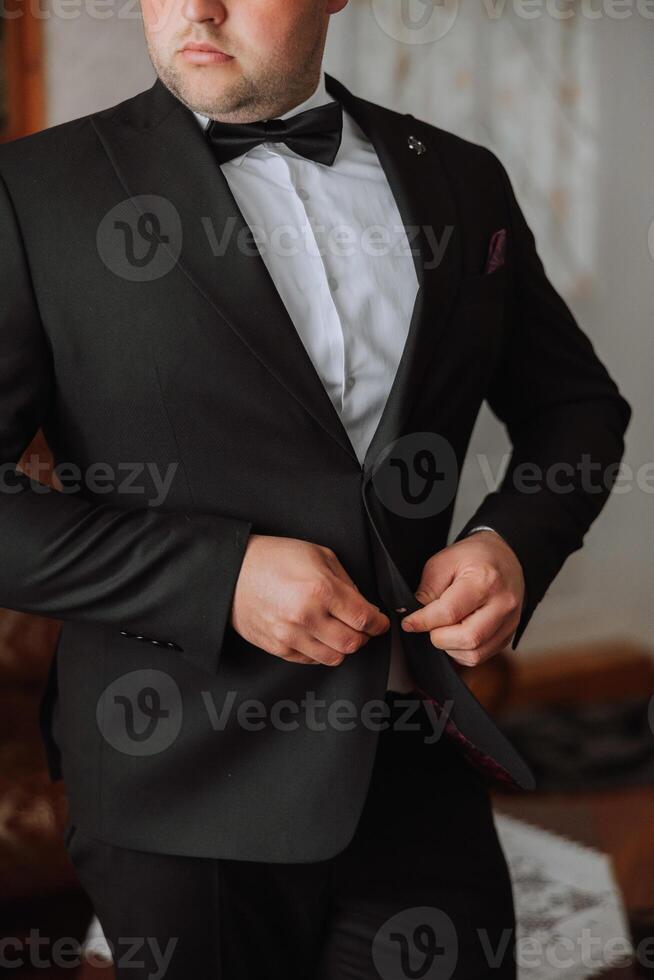 el hombre sujeta el botones en su chaqueta. el novio es preparando para el Boda ceremonia. detallado de cerca foto de manos