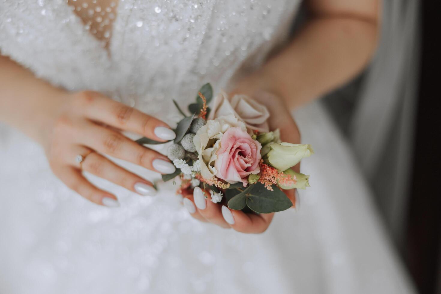 wedding boutonniere of flowers in the hands of the bride. Wedding details. The first meeting of the bride and groom. The bride is waiting for the groom. photo