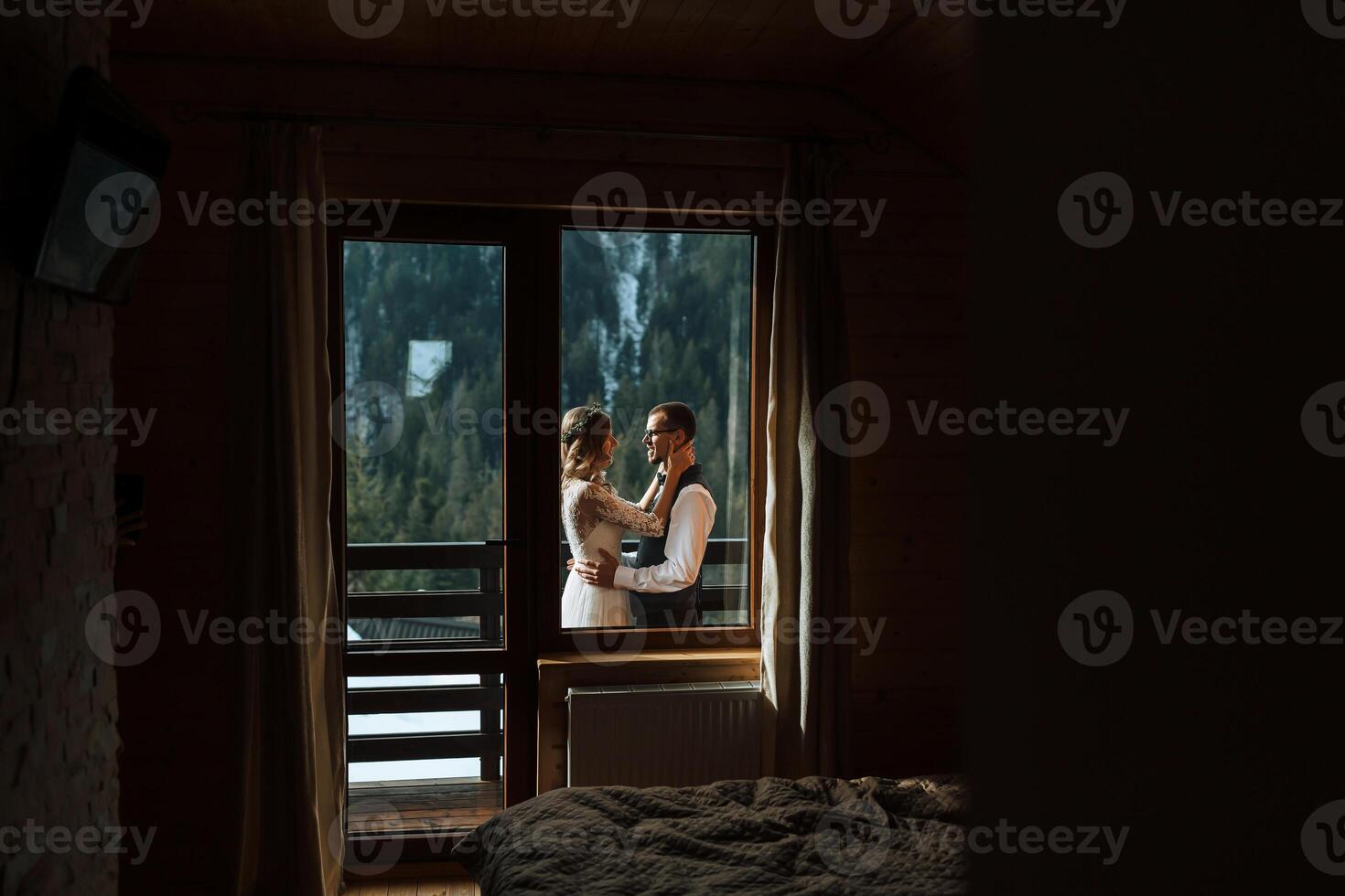 the groom puts a wreath on the bride against the background of snow-capped mountains. A wedding couple is celebrating a wedding in the mountains in winter. photo