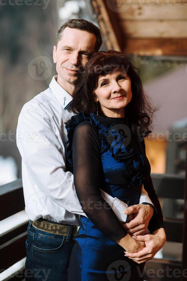 Happy senior adult mature classy couple hugging, bonding, thinking of good future. Carefree cheerful mid age old husband embracing wife looking away dreaming, enjoying wellbeing and love in new house. photo