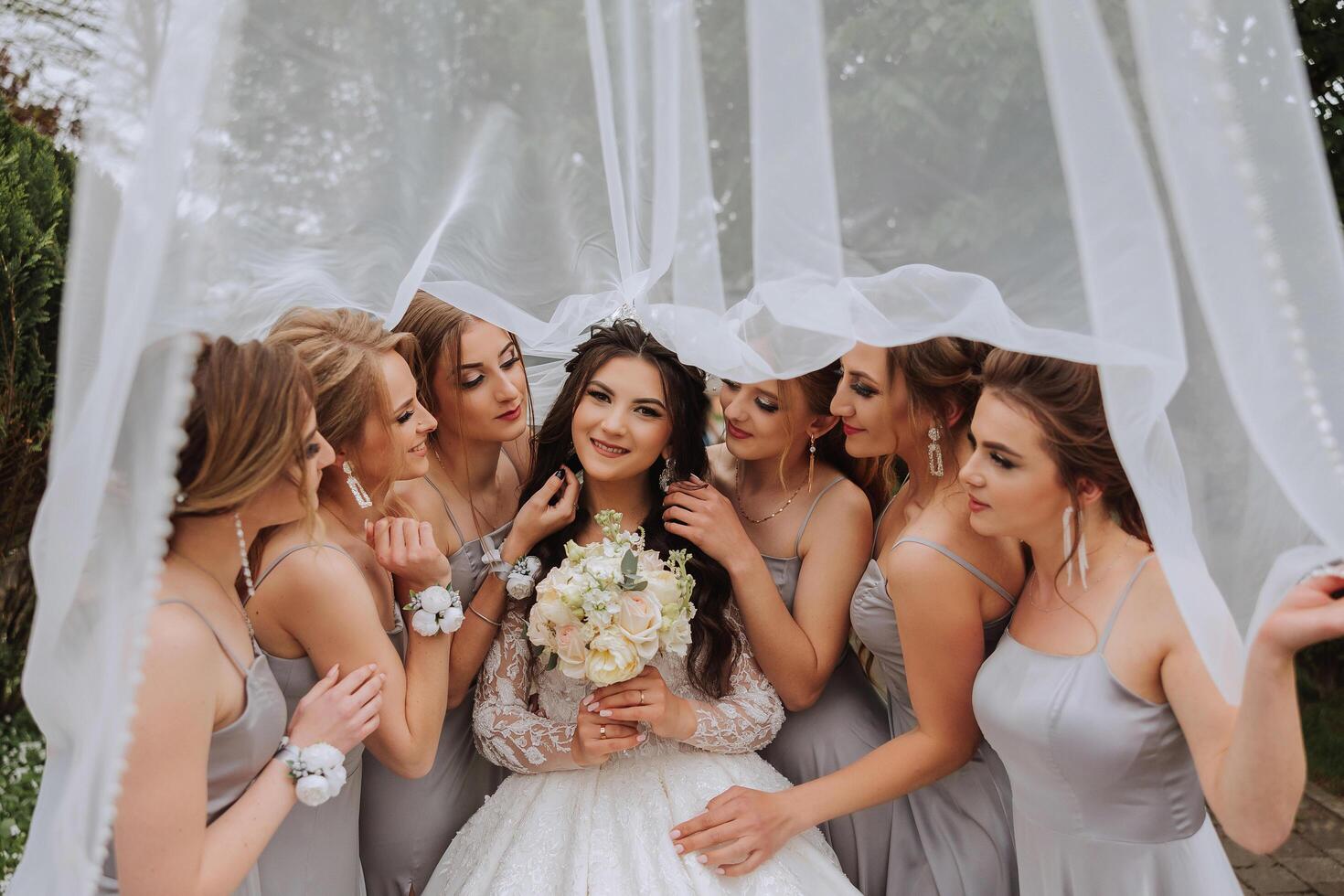 grupo retrato de el novia y damas de honor un novia en un Boda vestir y damas de honor en plata vestidos sostener elegante ramos de flores en su Boda día. foto