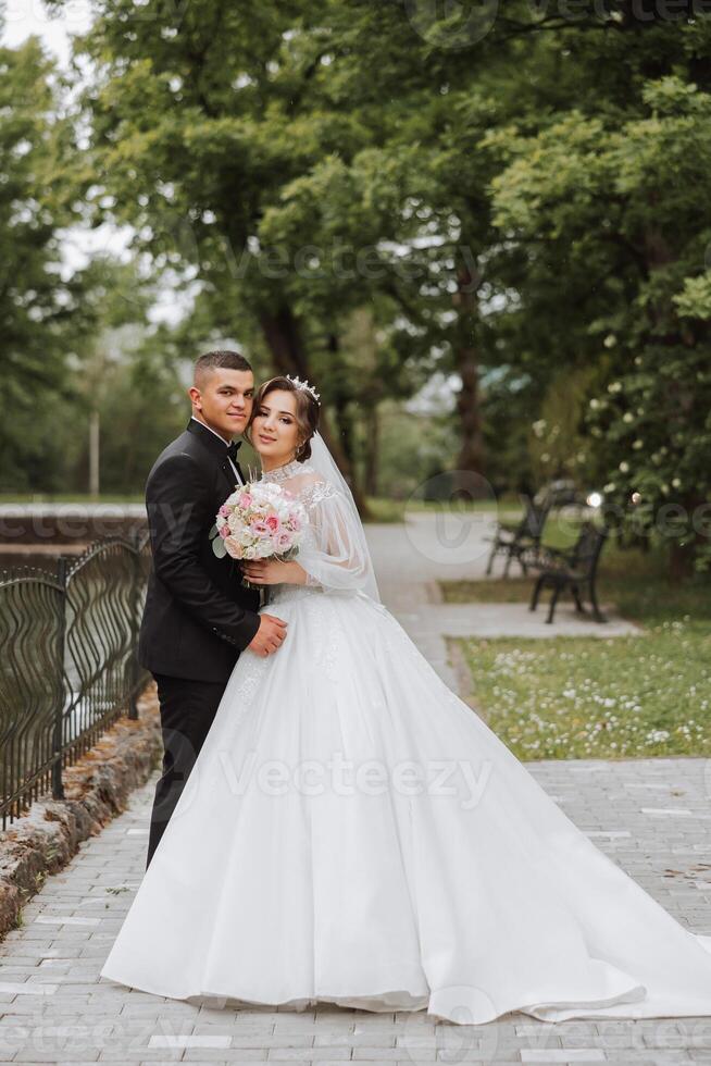 Wedding. Love and couple in garden for wedding. Celebrating the ceremony and commitment. Save the date. Trust. The groom embraces the bride. Tender kisses. Couple in love. Wedding portrait photo