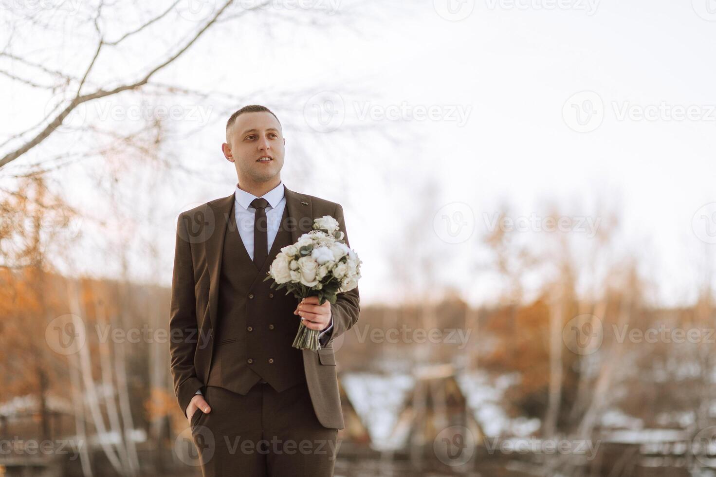 The groom holds a bouquet and poses while walking. Winter wedding. Portrait photo