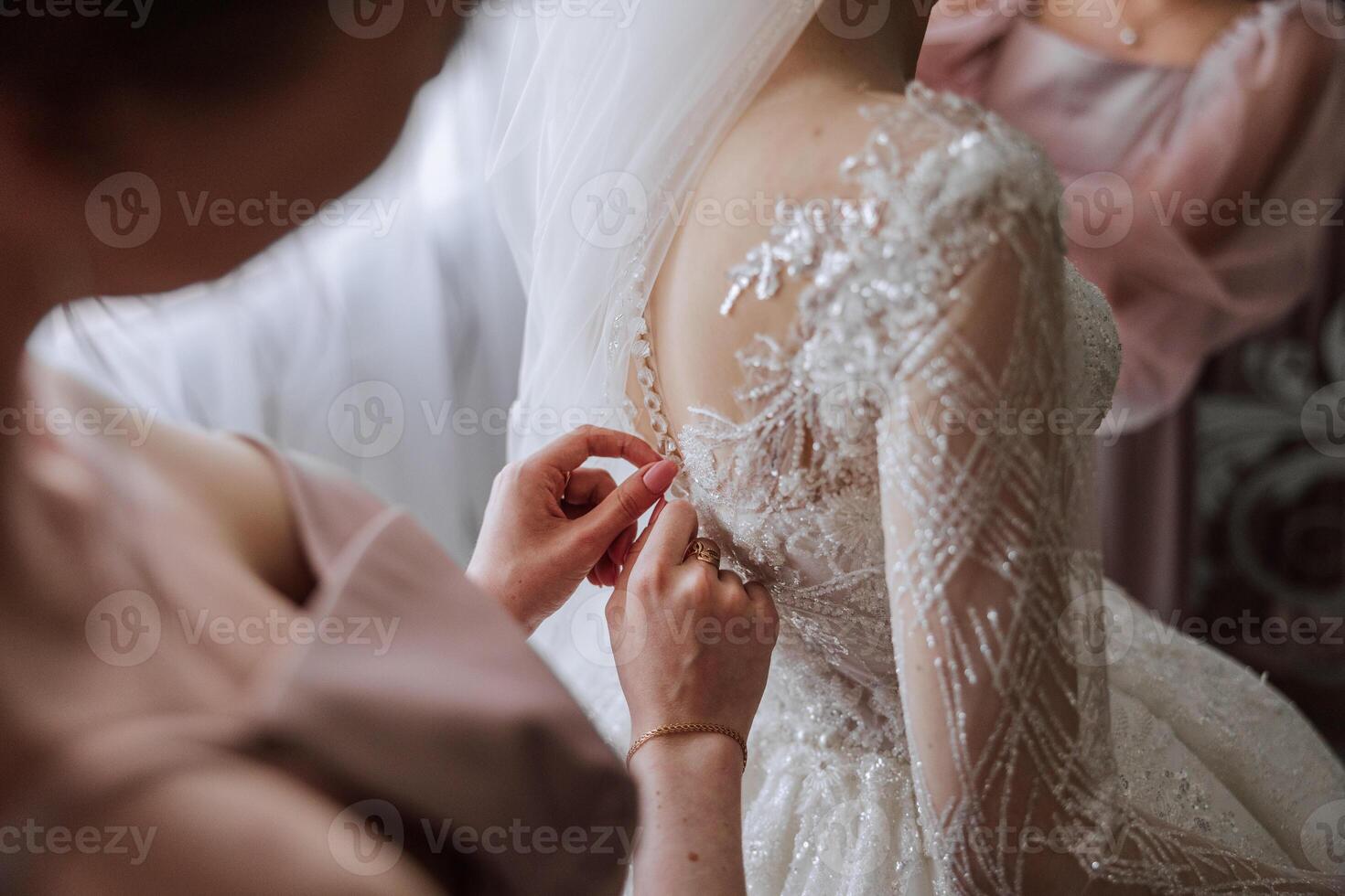 Mañana de el novia. el de la novia mucama de honor ayuda el novia cordón arriba su vestido, sujetar botones en el vestir o mangas novias ayuda el novia sujetar su vestir foto