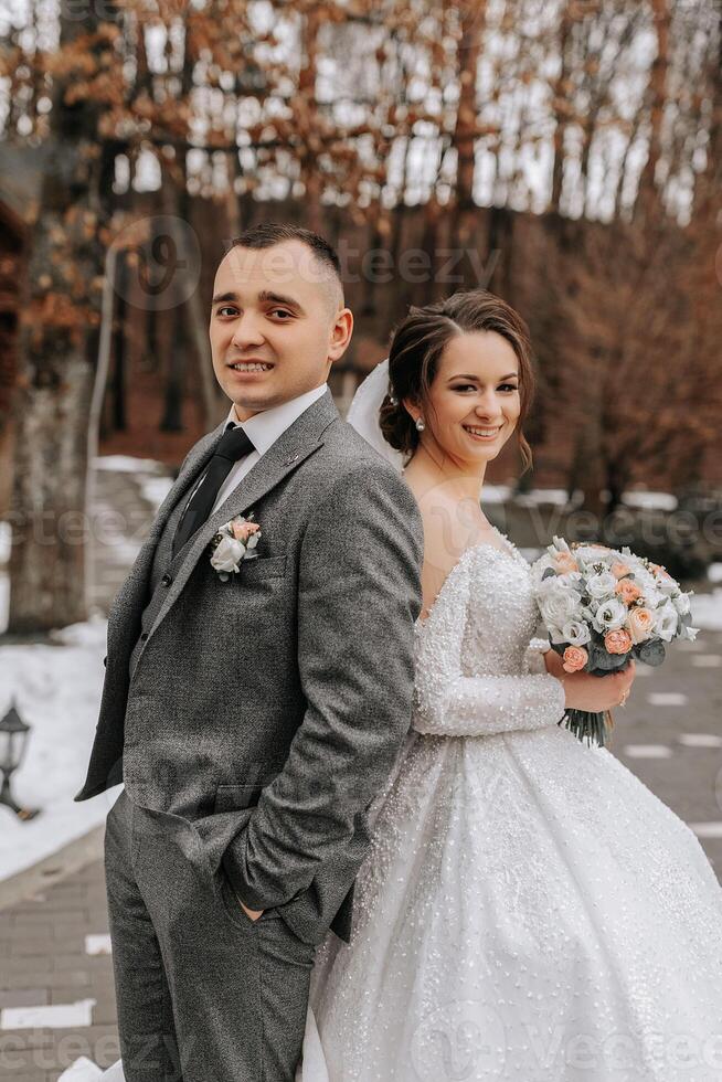 el novio viene arriba detrás el novia y abraza su. sincero emociones un caminar en el bosque. invierno Boda foto