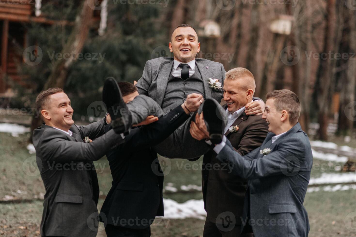 el novio y su amigos son vestido en trajes, engañando alrededor en naturaleza durante un foto disparo. un grupo de hombres. Boda en naturaleza