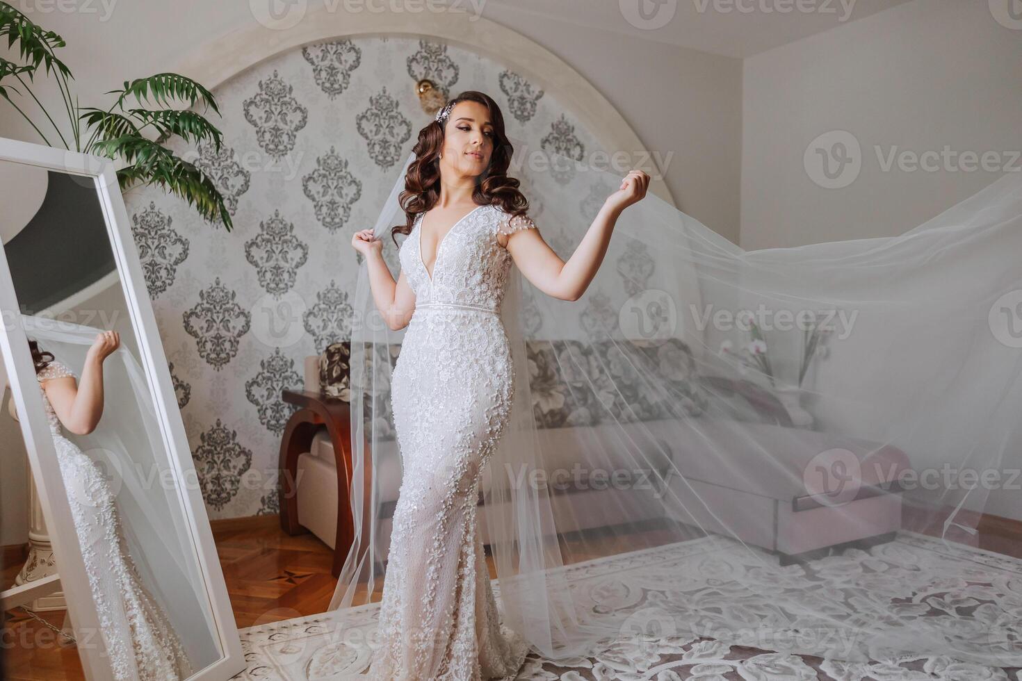 A wonderful beautiful portrait of a young bride. Beautiful bride with wedding makeup and jewelry wreath on long curly hair. Wedding photo model with brown eyes in a beautiful interior.