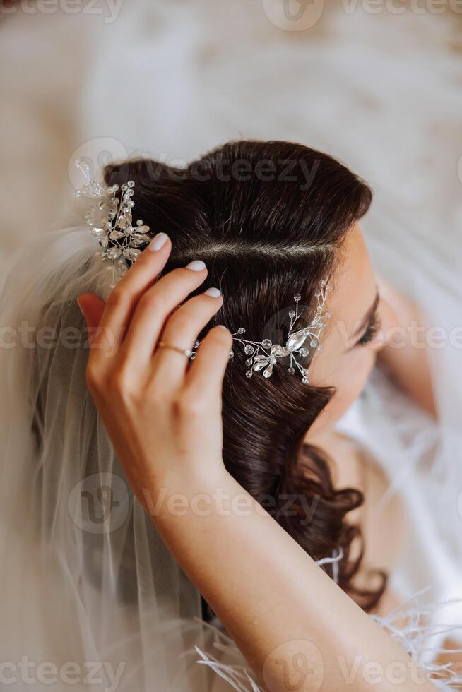 Luxury. Rich Stylish Brunette with Pearly Beads. Elegant Style. Close-up shot of female hair-do made as a strand of hair fixed with a gold hair clip. photo