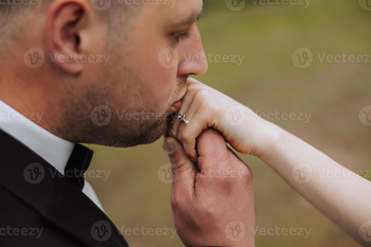 The groom kisses the hand of the bride. Cropped photo. In essential details. Tenderness photo