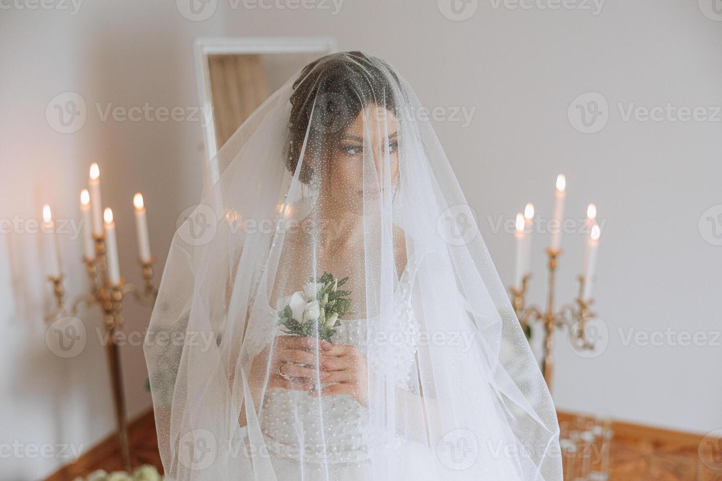 A luxurious bride with a beautiful hairstyle and a gorgeous dress is getting ready for the wedding ceremony in the morning. Morning photo of the bride at home or in a hotel room. Professional makeup.