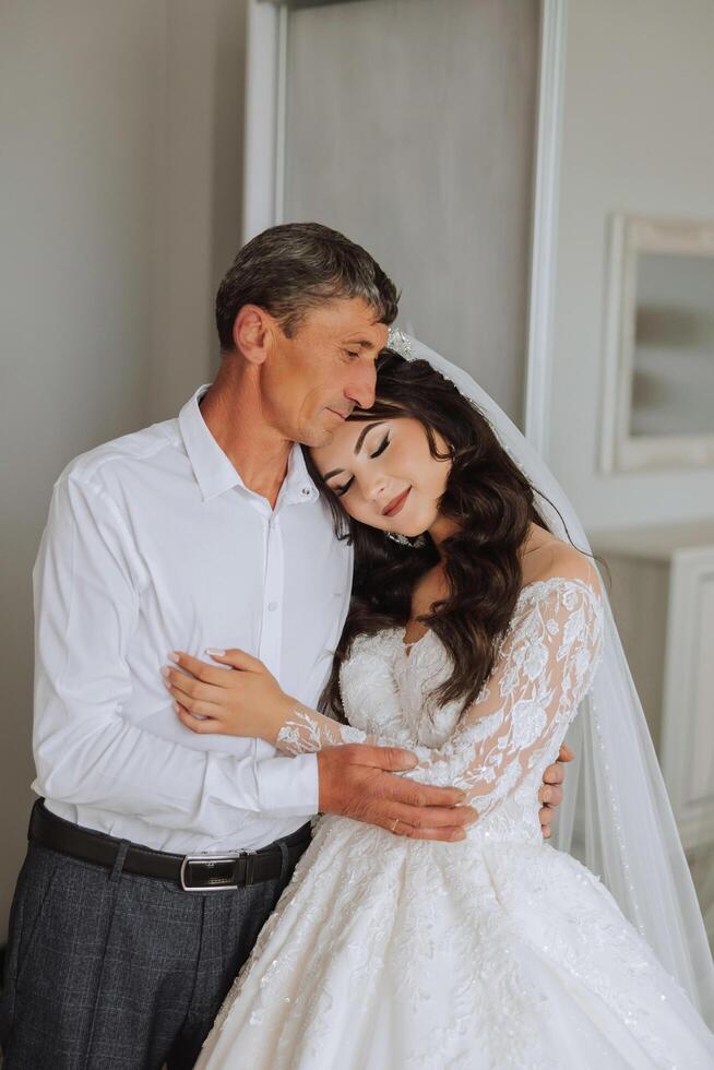 A beautiful bride with her father on her wedding day. The best moments of the wedding day. Daughter and father. photo