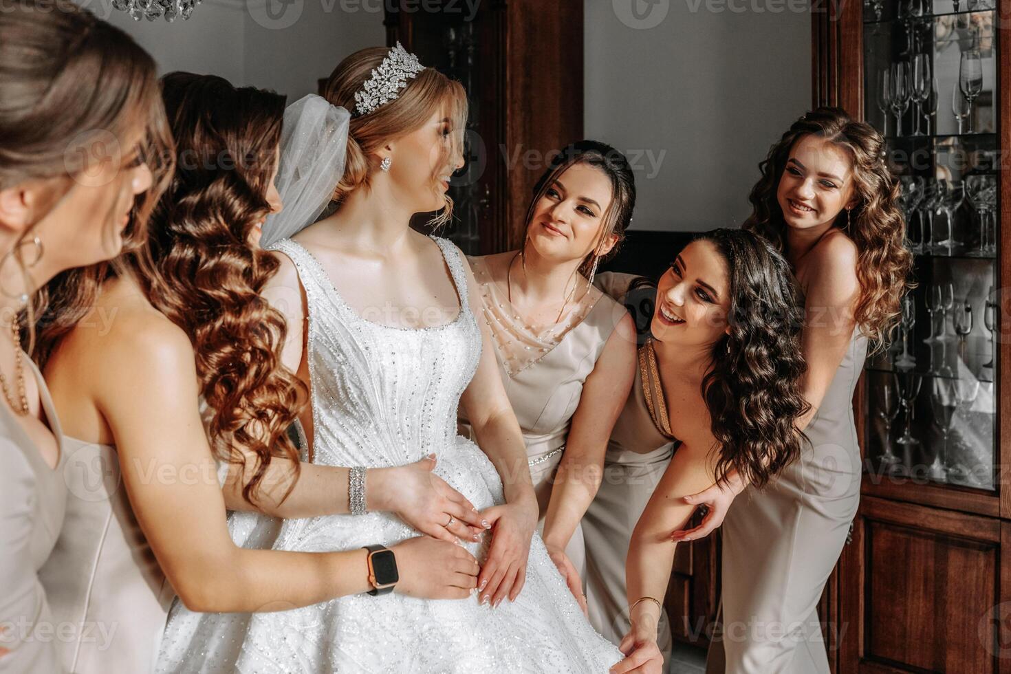 el novia en un blanco vestido, velo y novias en crema vestidos, posando en hermosa Encendiendo. Mañana de el novia foto