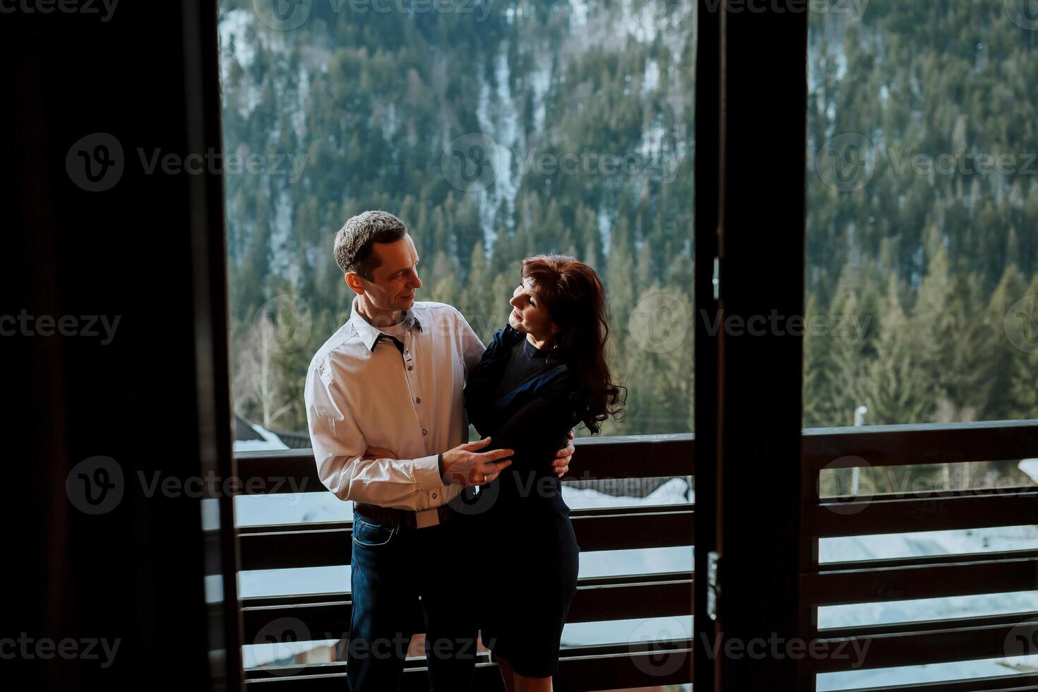 Happy senior adult mature classy couple hugging, bonding, thinking of good future. Carefree cheerful mid age old husband embracing wife looking away dreaming, enjoying wellbeing and love in new house. photo