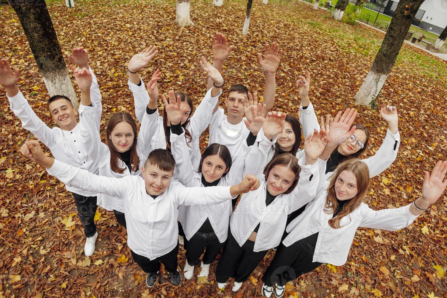 friendship, movement, action, freedom and people concept - group of happy teenagers or school friends posing and having fun outdoors against nature or forest background. photo