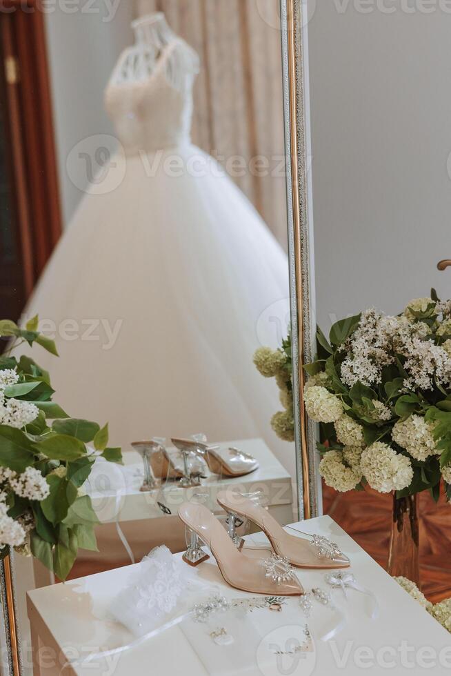 detalles de el novia. belleza es en el detalles. tacones altos nupcial zapatos. oro Boda anillo con un diamante. perfumes pendientes Boda en detalles. foto