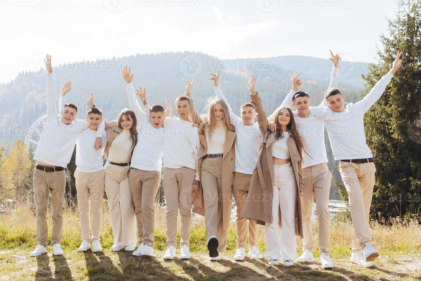 friendship, movement, action, freedom and people concept - group of happy teenagers or school friends jumping and having fun outdoors on the background of a beautiful place. photo