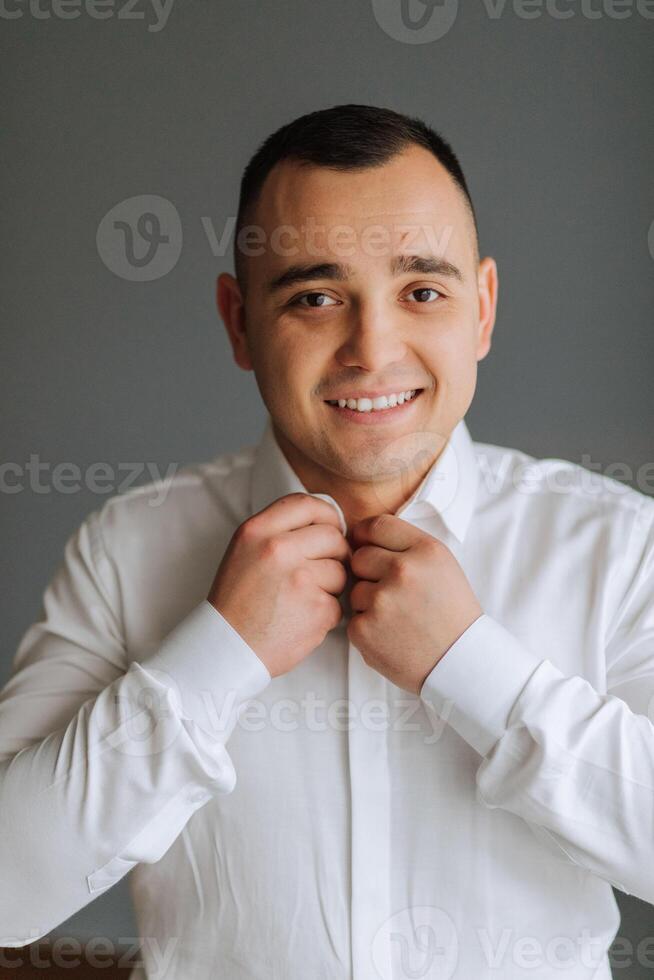 un hombre poses y sujeta un negro chaqueta. retrato de el novio. Moda y estilo. negocio foto